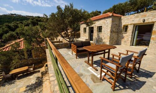 a patio with a table and chairs and a house at Casa Milos Aegean Suites in Alonnisos