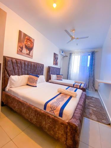 two beds in a room with a large bed with a couch at Bella luxury homes in Mombasa