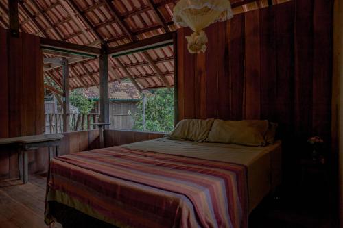 a bedroom with a bed in a wooden room at Bangalôs Suítes na Floresta Encantada in Santarém