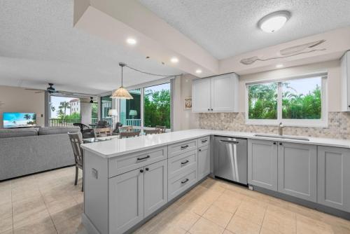 eine große Küche mit weißen Schränken und ein Wohnzimmer in der Unterkunft Island Beach Club #220B in Sanibel