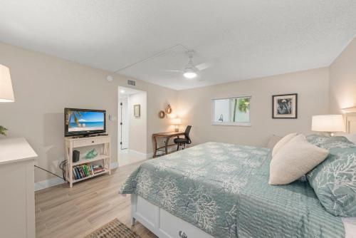 ein Schlafzimmer mit Bett und Flachbildfernseher in der Unterkunft Island Beach Club #220B in Sanibel