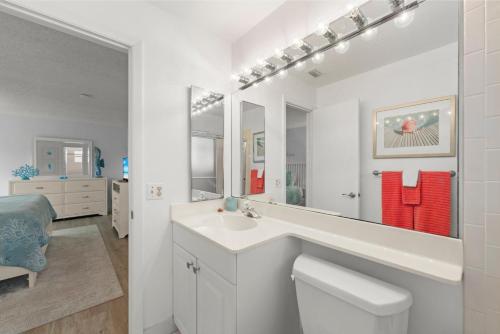 a white bathroom with a sink and a mirror at Blind Pass #E209 in Sanibel