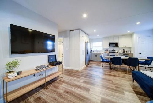 a living room with a large flat screen tv on a wall at Stylish 4BR Home - Modern & Bright Interior in Charlotte