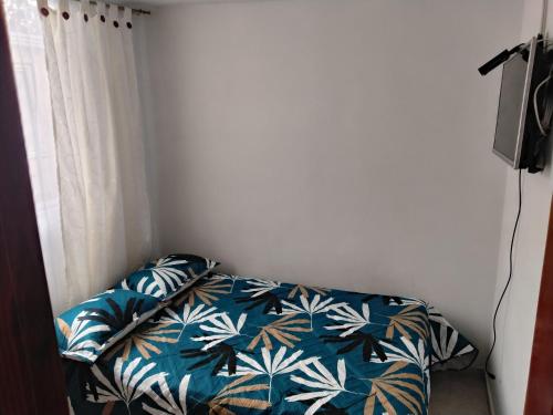 a bedroom with a bed with blue and green leaves at Apartamento cerca del aeropuerto in Bogotá