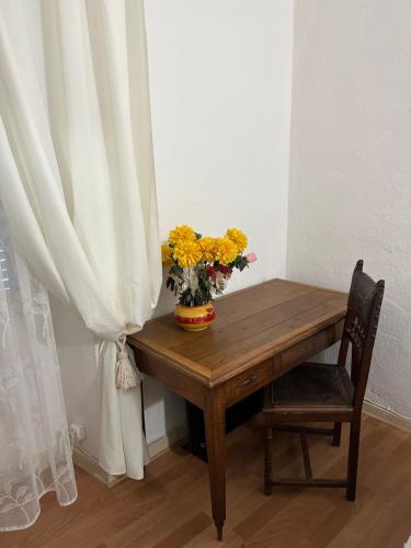 une table en bois avec un vase de fleurs dessus dans l'établissement Casa Bella Centre de Corsica, à Corte
