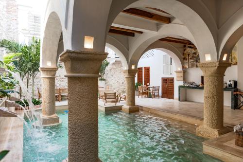 een binnenzwembad in een gebouw met zuilen en water bij Hotel Palacio del Agua by Faranda Boutique in Cartagena