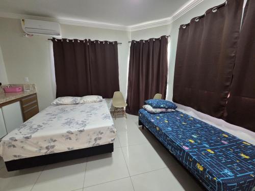 une chambre avec deux lits jumeaux et une cuisine dans l'établissement Aconchego Perfeito em São Pedro SP, à São Pedro