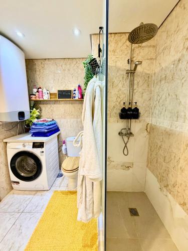 a bathroom with a shower and a washing machine at Beachfront Private Apartment in Pueblo Torviscas Sunset Harbour in Adeje