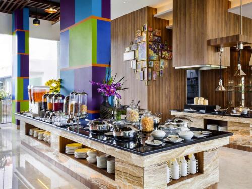 un buffet dans une cuisine aux murs colorés dans l'établissement ibis Styles Cikarang, à Cikarang
