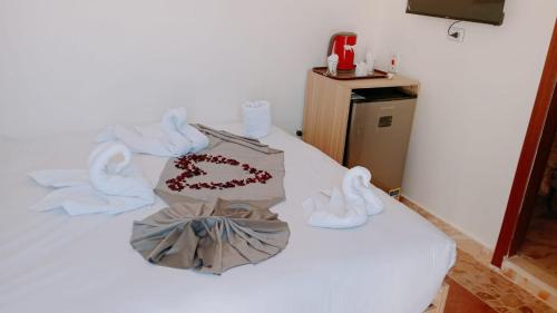 Una cama blanca con toallas y un pastel encima. en apartment pyramids view, en Giza