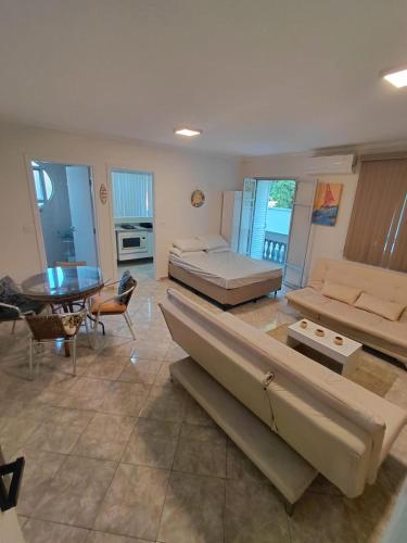 ein großes Wohnzimmer mit 2 Betten und einem Tisch in der Unterkunft Studio pé na areia Pereque - Açu in Ubatuba