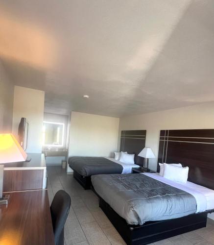 a hotel room with two beds and a desk at Stay7 studios Hotel Phoenix Metro in Phoenix