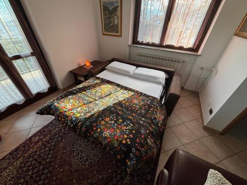 een slaapkamer met een bed met een kleurrijke deken erop bij Fusero1 relax vero borgata fusero 20 giaveno in Coazze