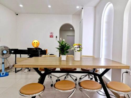 a dining room with a table and a piano at MaMa Hostel CNX in Chiang Mai