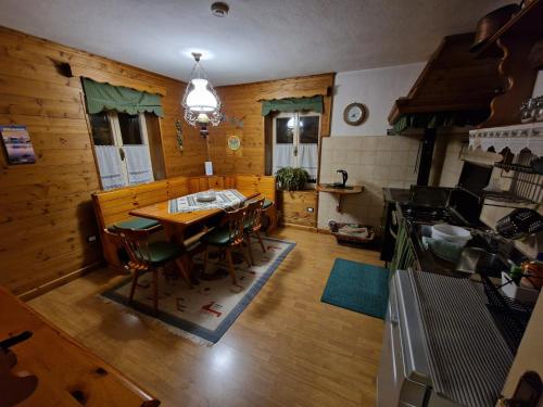 eine Küche und ein Esszimmer mit Tisch und Stühlen in der Unterkunft Appartamento Lorena in Rocca Pietore