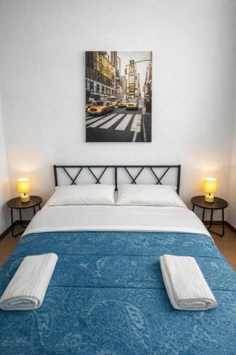 a bedroom with a blue bed with two lamps on tables at Easy Room Italy Central Station in Milan
