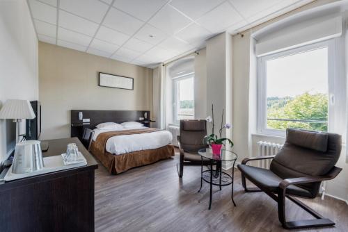 ル・シャンボン・シュル・リニョンにあるHôtel De La Plageのベッド、テーブル、椅子が備わるホテルルームです。