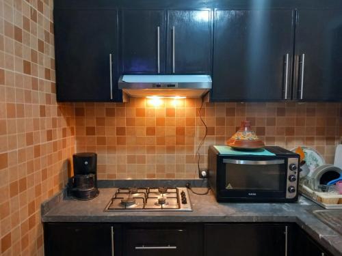 a kitchen with a stove and a microwave at bel appartement à Martil in Martil