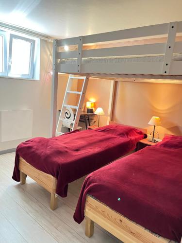 een slaapkamer met 2 bedden met rode lakens en een ladder bij Villa Josèphe in Capbreton