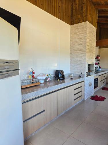 una cucina con banconi bianchi e piano di lavoro di Casa temporada Grecco Vidal a Venda Nova do Imigrante