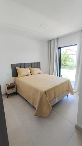 a bedroom with a bed and a large window at Mansão dos Mares 06 in Ilhéus