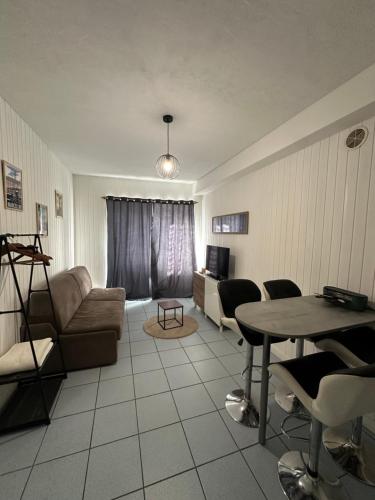 ein Wohnzimmer mit Sofa und Tisch in der Unterkunft Le petit studio Rue de l'Imprimerie in Gap