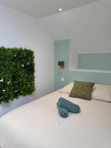 un letto bianco con un asciugamano blu sopra di La Jungle - T2 à Melesse a Melesse