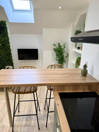 una sala da pranzo con tavolo e sedie in legno di La Jungle - T2 à Melesse a Melesse