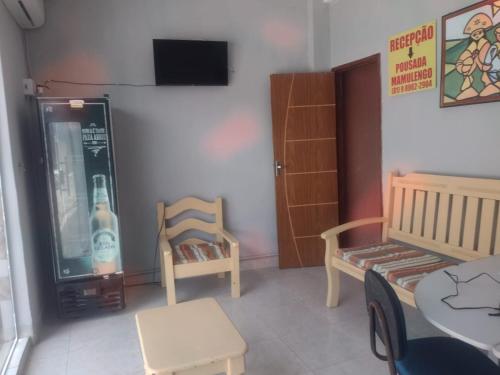 een kamer met 2 stoelen, een tafel en een televisie bij Pousada Mamulengo in Porto De Galinhas