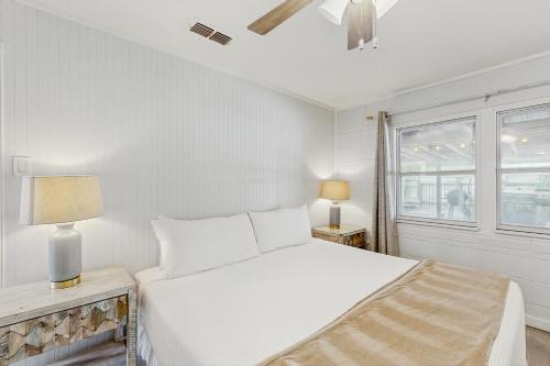 a white bedroom with a bed and a window at The Saltbox in Padre Island