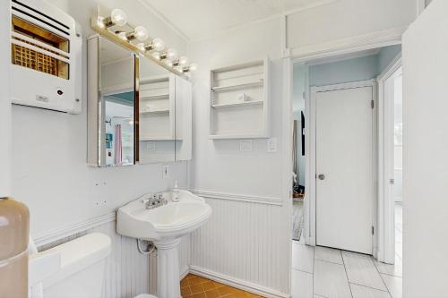 a white bathroom with a sink and a mirror at The Saltbox in Padre Island