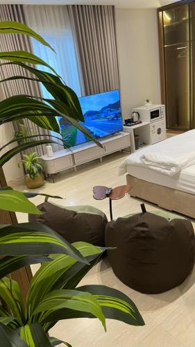 a bedroom with a bed and a potted plant at Mfj Marbella Stay دخول ذاتي بموقف خاص وإطلالة مسبح in Al Khobar
