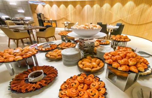 a table with many different types of bread and pastries at Hotel Nacional, Rio de Janeiro, Suíte Luxo com Banheira in Rio de Janeiro