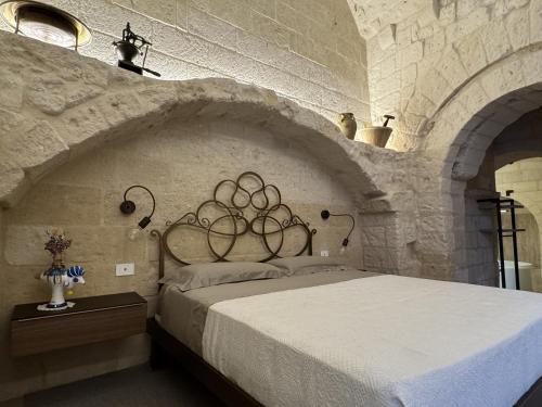 a bedroom with a large bed in a stone wall at L'Incanto Caves in Matera