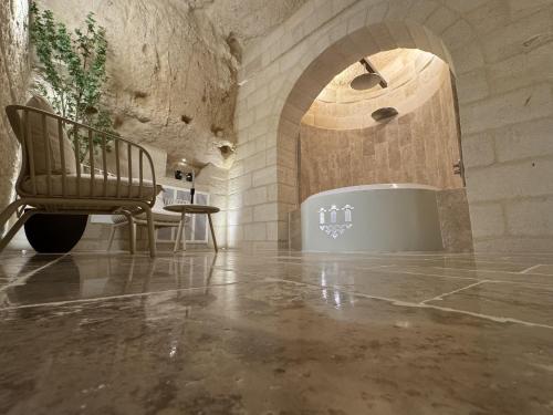 een kamer met een stoel en een badkuip in een stenen muur bij L'Incanto Caves in Matera