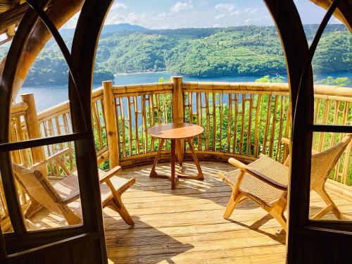een veranda met stoelen en een tafel en uitzicht bij Les Terrasses Ceningan in Nusa Lembongan