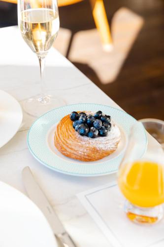 a pastry on a plate on a table with a glass of wine at Surf & Sand Laguna Beach in Laguna Beach