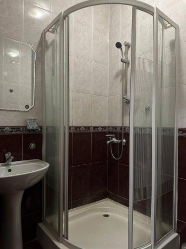 een badkamer met een douche en een wastafel bij Сункар in Uchitelʼ