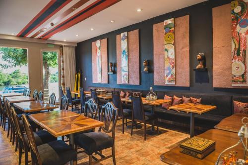 een eetkamer met houten tafels en stoelen bij Los Muelles Boutique Hotel in Carmelo