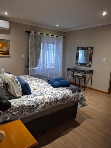 a bedroom with a bed with blue pillows on it at Spacious Suite in Somerset West in Somerset West