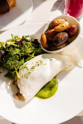 a plate of food with a plate of food with a salad at Surf & Sand Laguna Beach in Laguna Beach