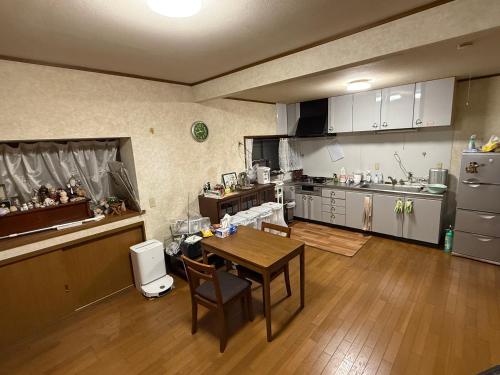 een keuken met een tafel en een keuken met een aanrecht bij 桜の家 in Saitama
