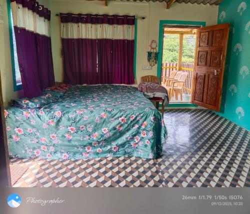 a bedroom with a bed with a blue comforter at Omkar Homestay Adgaon Beach Sea View Next to Diveagar 2 in Adgaon