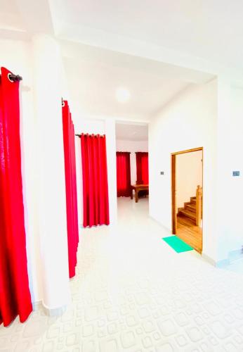 Una habitación con cortinas rojas y un espejo. en Charith Guest, en Tangalle