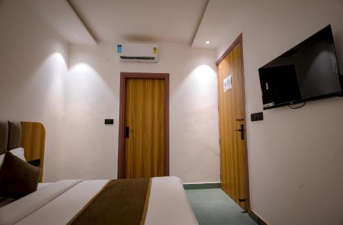 een slaapkamer met een bed en een flatscreen-tv bij Troy Resorts and wellness in Zirakpur