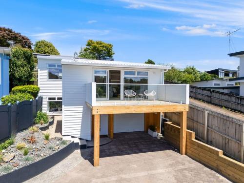 a tiny house with a deck with two chairs on it at Luxury Town house with fabulous views in Hamilton