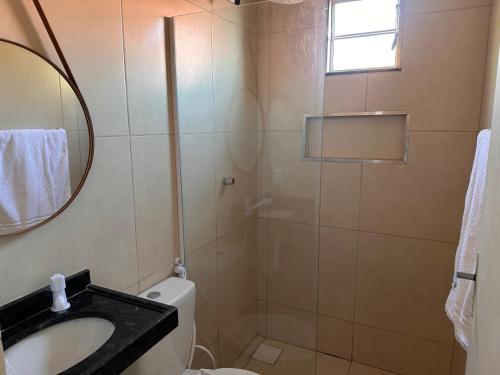 a bathroom with a toilet and a sink and a mirror at Suite 05 em casa Beira mar, com ar condicionado , cozinha completa com Micro ondas air fryer forno elétrico fogão Geladeira freezer gelagua e cafeteira elétrica Tudo para vc se sentir em casa além de um Deck com churrasqueira vista mar in Icapuí