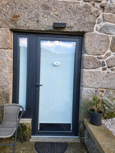 una porta in un muro di pietra con una sedia e una pianta di Ermida Vista Douro a Baião