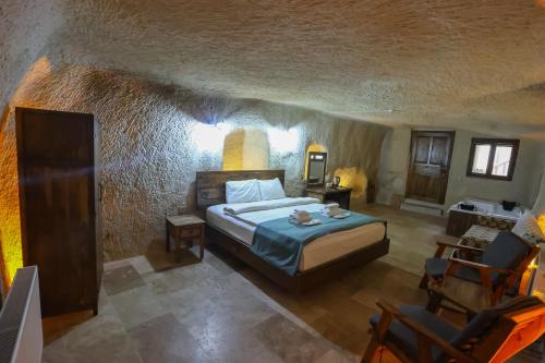 a bedroom with a bed in a stone room at Kayaharman cave otel in Nar