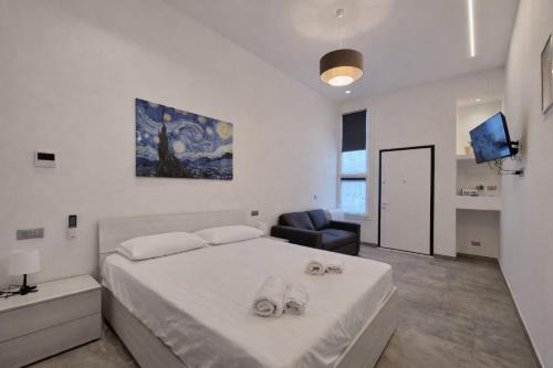 een witte slaapkamer met een bed en een stoel bij GemmaHouse in Casalecchio di Reno